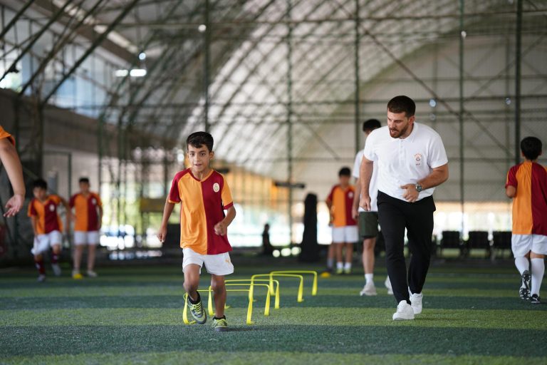 Energetic indoor soccer training with kids and coach, focusing on agility and teamwork.